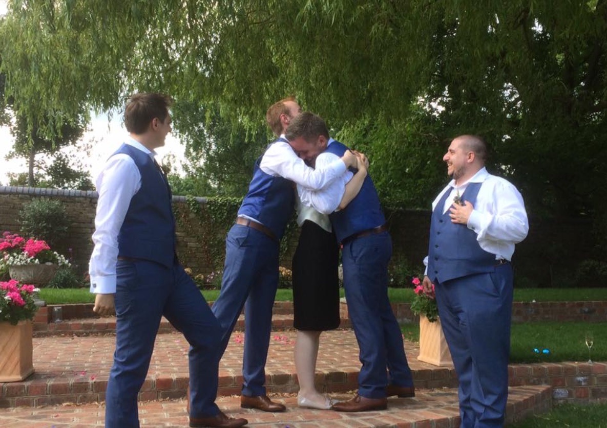 Four groomsmen hug Steph